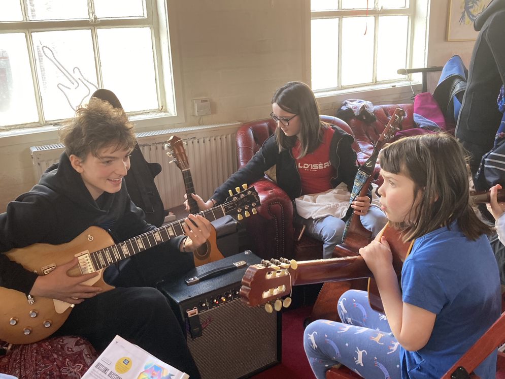 Young people trying out an instrument at World Heart Beat Open Day