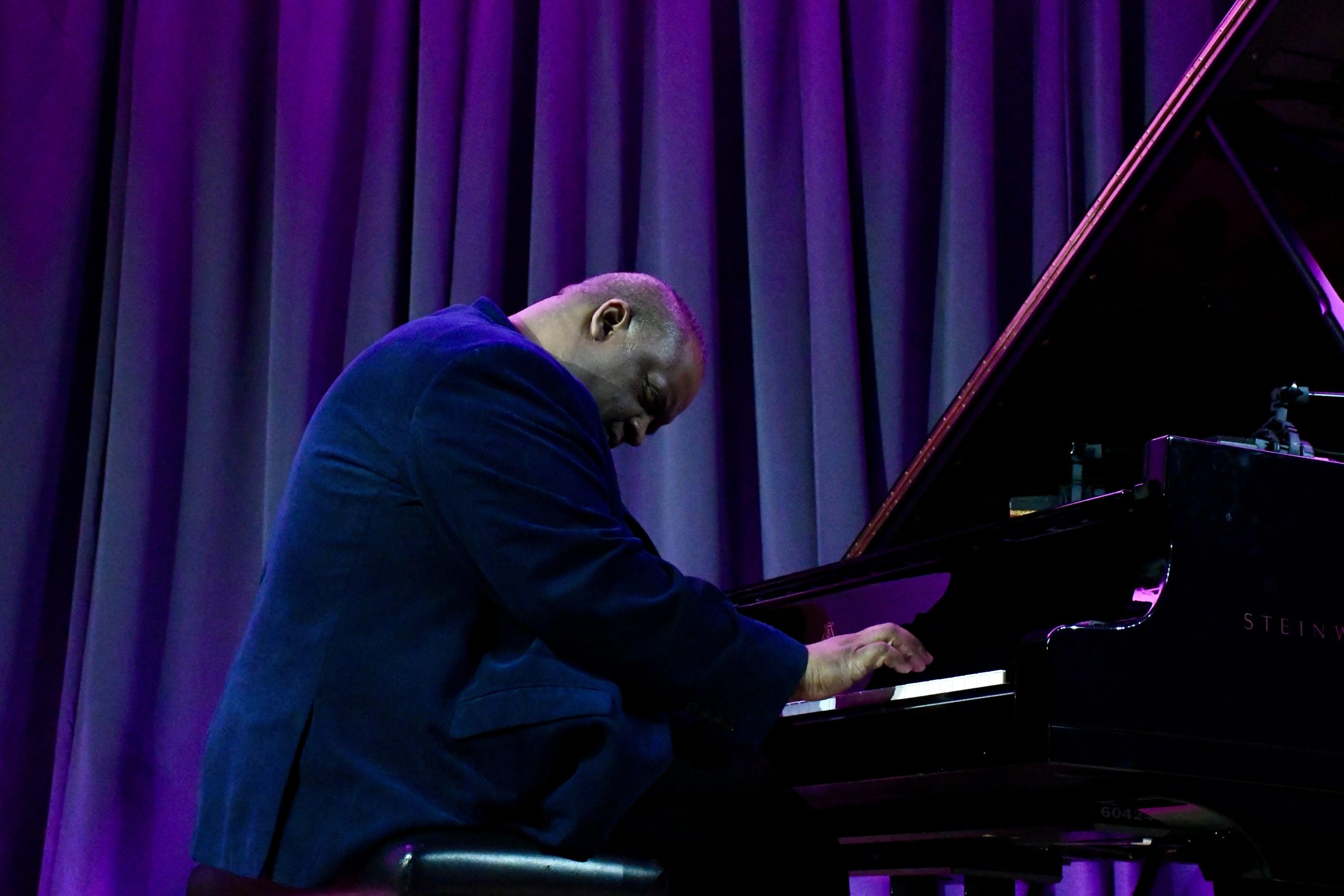 julian playing piano purple background