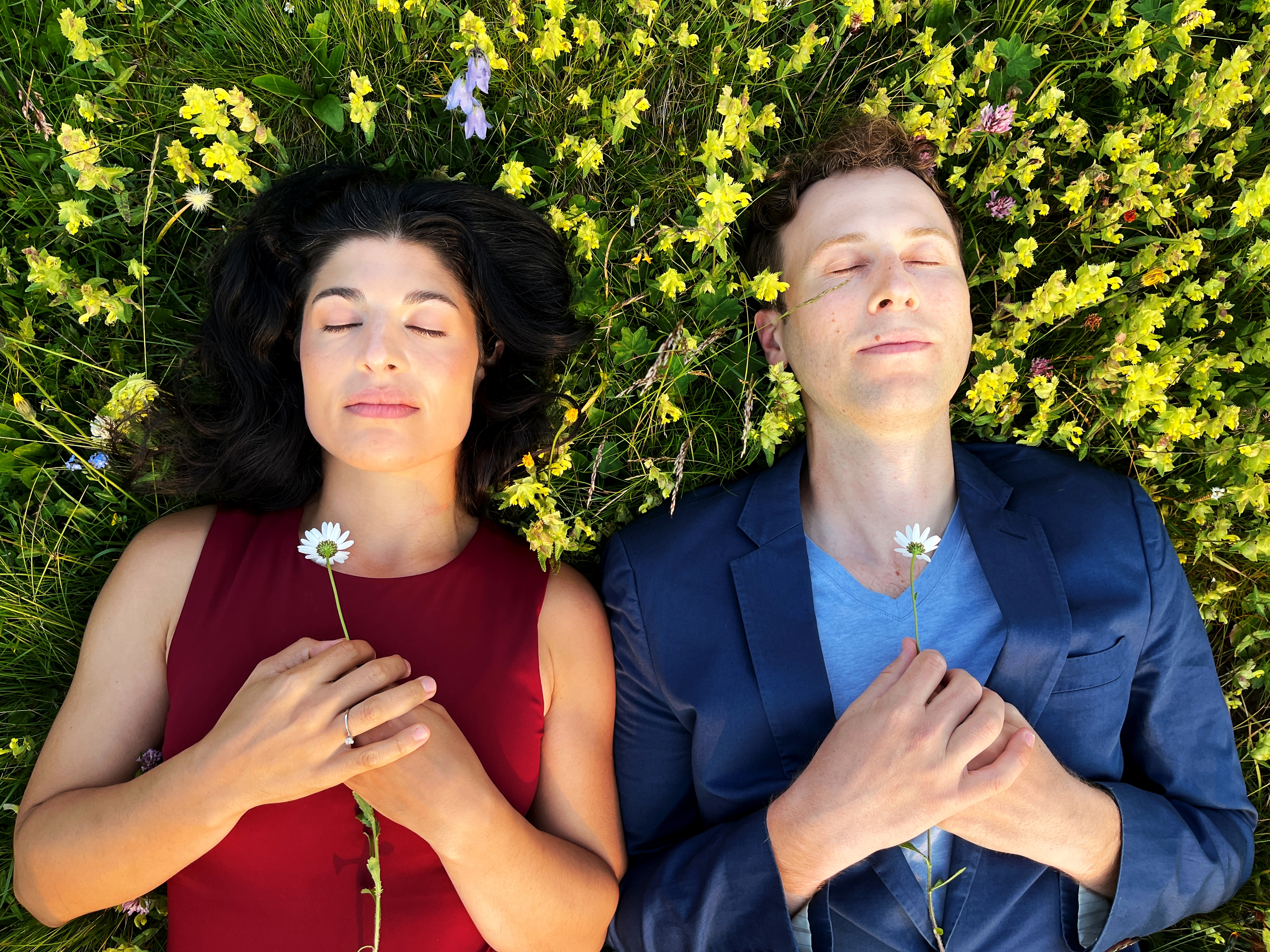 Infinitesimal at World Heart Beat - 2 opera performers lie amoungst a field of flowers,